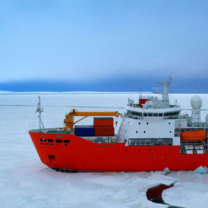 Icebreaker ship navigating Arctic sea ice while maintaining satellite communication in remote polar waters.